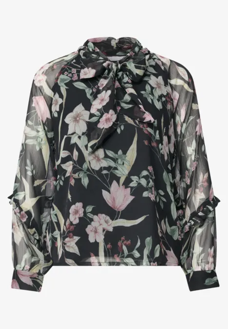 Schwarze, transparente Bluse mit weitem Schnitt, floralen Pastellblüten und verspielter Schleifenkragen.