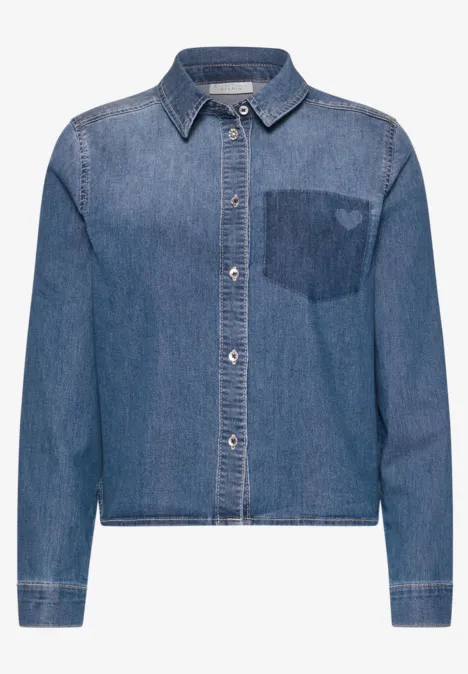 Ein locker geschnittene Jeansjacke mit Hemdkragen und Herzstickerei auf der Brusttasche.