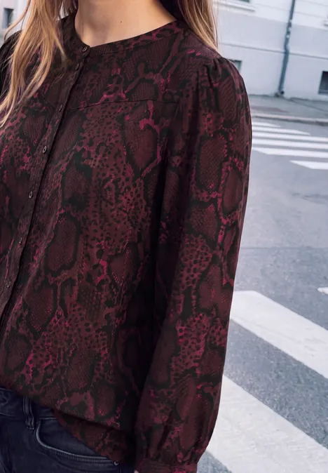 3/4-Arm Tunika mit Rundhals und Snake-Print russet red Frau in dunkelroter Schlangenmuster-Bluse und Jeans auf der Straße.
