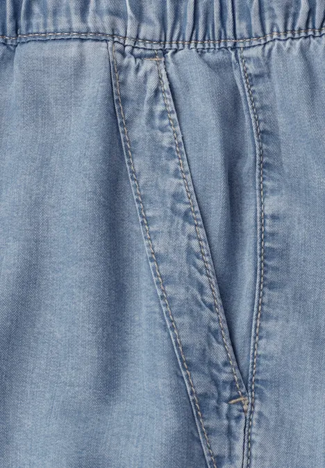 Hellblaue Jeansoptik mit elastischem Bund und schräger Tasche.
