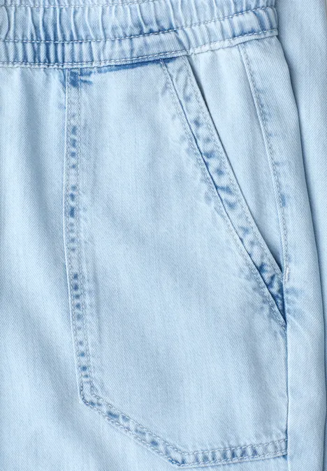 Lichtblauwe jeansbroek met elastische taille en een zijzak.