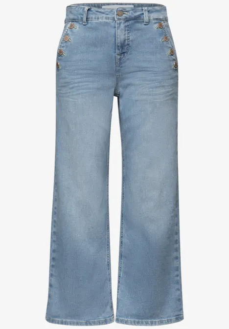 Hooggetailleerde lichtblauwe jeans met brede pijpen en decoratieve knopen aan de zijkant.