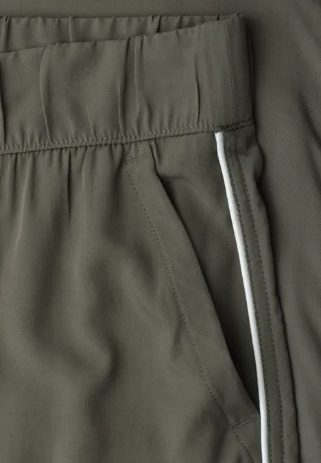 Wide Leg Culotte im Loose Fit mit Piping ashen olive Nahaufnahme einer olivgrünen Sporthose mit elastischem Bund, Seitentasche und weißem Streifen.