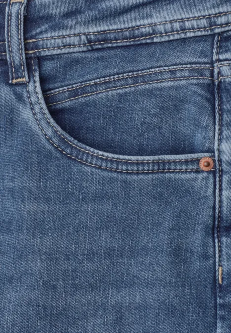 Gros plan sur un jean bleu avec poche visible.