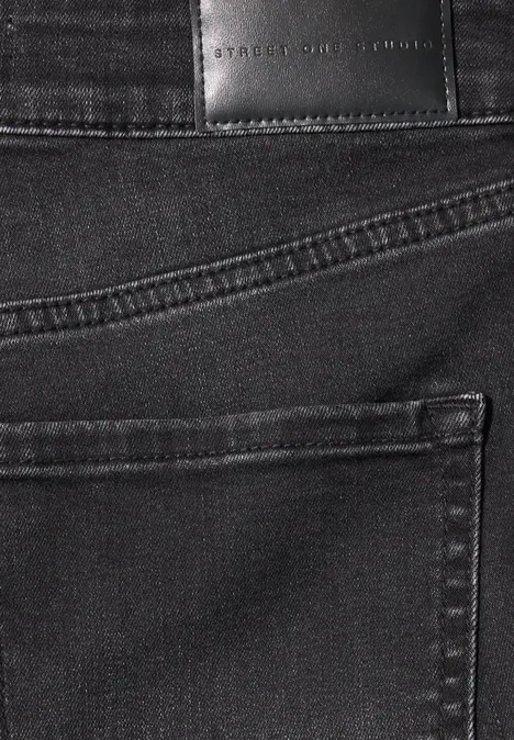 Nahaufnahme einer schwarzen Jeans mit aufgesetzter Gesäßtasche und Markenlederpatch.