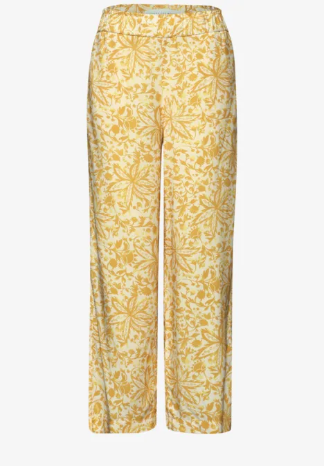 Losse gele en witte broek met bloemetjesmotief.