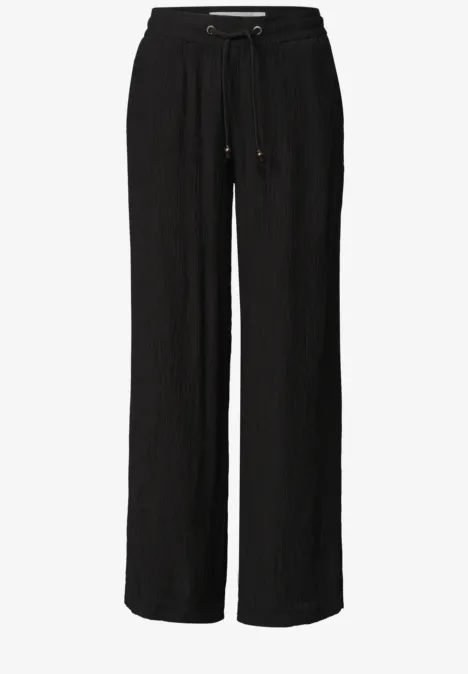 Schwarze, locker sitzende Hose mit weitem Bein und Kordelzugbund.
