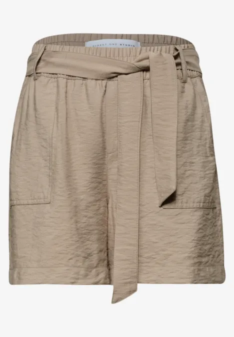 Short beige texturé, taille haute élastique avec ceinture nouée et poches plaquées.