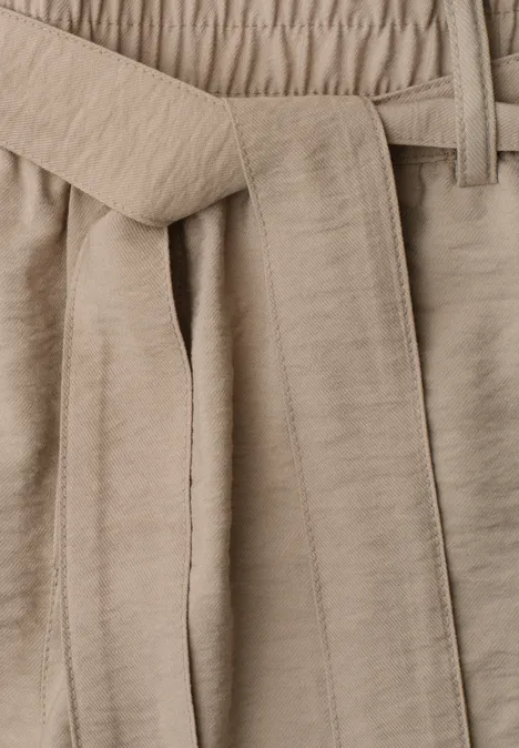 Pantalon beige à taille élastique avec ceinture en tissu assorti, style décontracté.