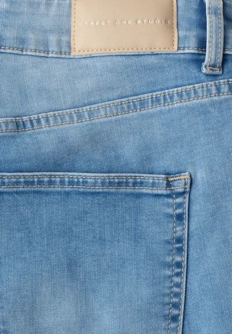 Close-up van een blauwe spijkerbroek met achterzak en ceintuurlussen.