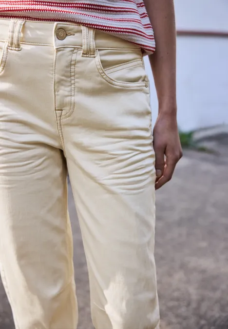 Close-up van een persoon in beige broek en een gestreept shirt