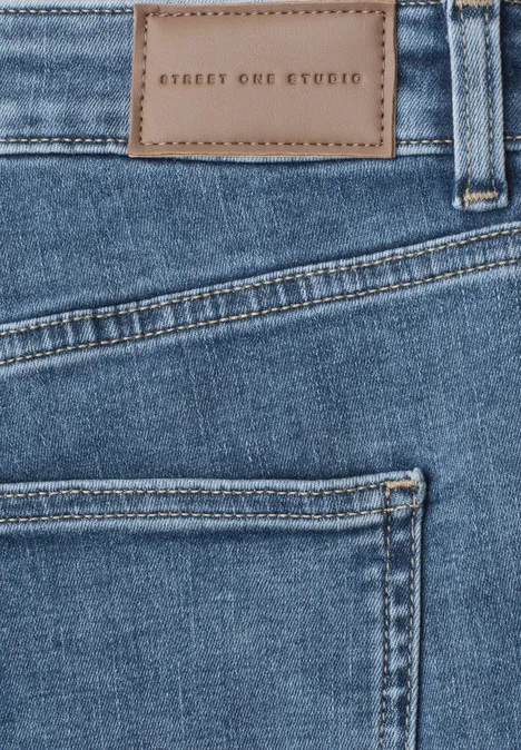 Mid Waist Skinny Leg Jeans im Skinny Fit mid blue soft washed Nahaufnahme einer blauen Jeans mit aufgestickter Lederpatch 'STREET ONE STUDIO' über der Gesäßtasche.
