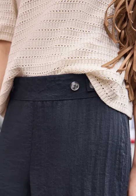 Mid Waist Wide Leg Hose im Leinen-Look maritime blue Lockeres, hellbeiges Strickoberteil über dunkelblauer Hose mit hohem Bund und Knopf.