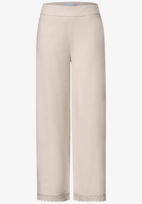 Wide Leg Hose mit Crochet-Detail vanilla sand Bequeme, hellbeige Hose mit weitem Schnitt und zarter Spitzenbordüre am Saum