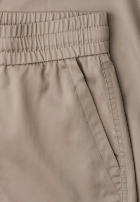Slim Leg Joggpants in Cupro-Touch-Qualität dark stone sand Nahaufnahme einer beigen Hose mit elastischem Bund und schräger Tasche.