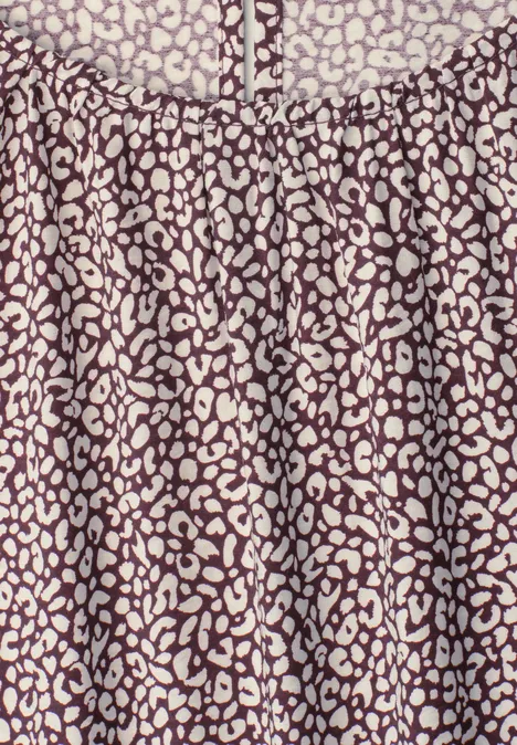 Bluse mit lila-beigem, abstraktem Leopardenmuster und Rundhalsausschnitt.