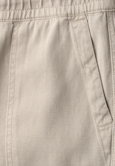 Broek met Mid Waist-taille en Straight Leg-pijpen in een Loose Fit-pasvorm dark creamed sand Close-up van een beige stoffen broek met elastische taille en zijzak.