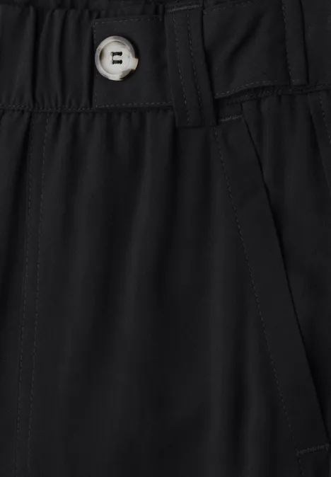 Gros plan sur la ceinture noire d'un pantalon avec bouton et poche