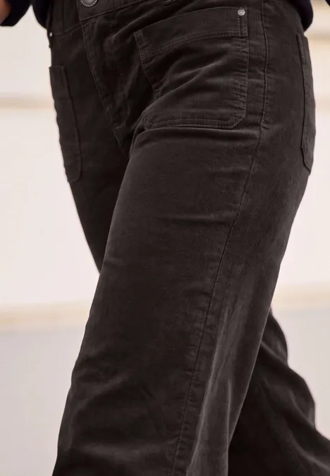 Nahaufnahme einer Person in schwarzen Jeanshosen.