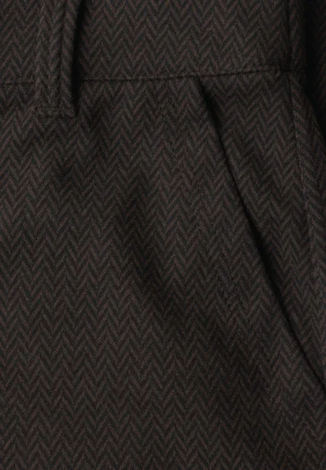 Détail d'un pantalon en tissu chevrons brun foncé avec poche biseautée et ceinture.