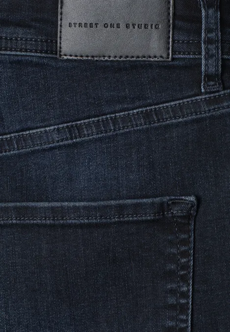 High Waist Barrel Leg Jeans w stylu Loose Fit blue black authentic wash Zbliżenie ciemnych dżinsów z tylną kieszenią i skórzaną naszywką 'Street One Studio' na pasie.
