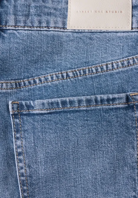 Blaue Jeans mit sichtbar aufgesetzter Gesäßtasche und Stoffetikett.