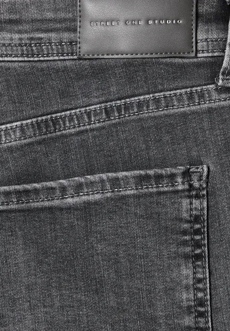 Nahaufnahme schwarzer Jeans mit Taschennaht und Lederetikett ‚SELECTED‘.