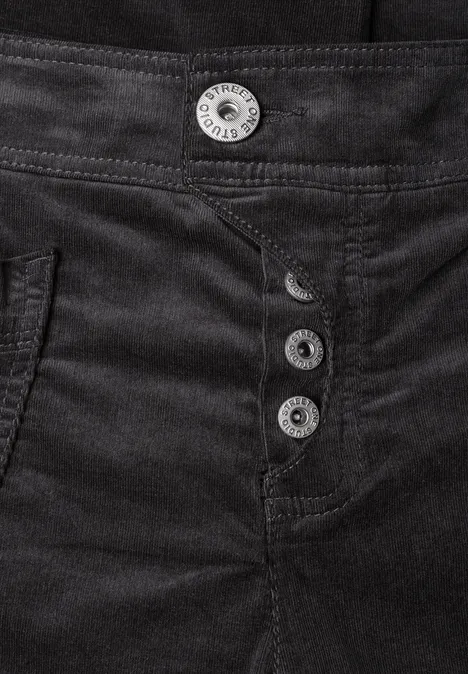 Gesloten foto van een zwarte broek met vier zilveren knopen op de taille, zichtbaar stiksel.