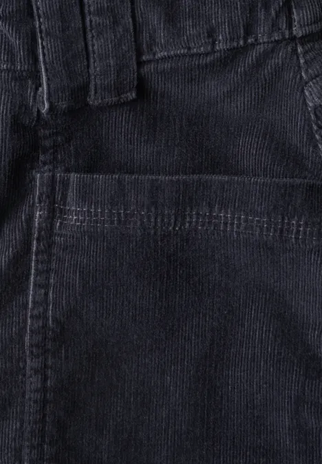 Nahaufnahme einer dunklen Cordhose mit sichtbarer Fronttasche und Gürtelschlaufen