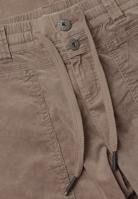 Mid Waist Barrel Leg Hose im Loose Fit henna brown Nahaufnahme einer braunen Cordhose mit Bündchen, Kordelzug, Taschen und Metallknöpfen.