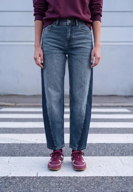 Relaxed Barrel Leg Leg Jeans im Loose Fit mid blue washed Eine Person steht auf einem Zebrastreifen, trägt gerade geschnittene Jeans und dunkelrote Schuhe.