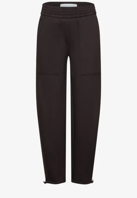 Mid Waist Barrel Leg Hose im Loose Fit charred brown Schwarze Jogginghose mit elastischem Bund, aufgesetzten Taschen und Reißverschlüssen an den Knöcheln.