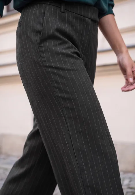 High Waist Straight Leg Hose im Casual Fit Black Person trägt dunkelgraue Nadelstreifenhose, nur Beine und Hüftbereich sind sichtbar.