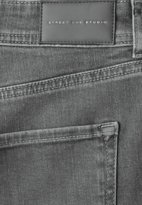 Nahaufnahme einer grauen Jeans mit Gesäßtasche und schwarzem Markenlabel 'Street One Studio'.