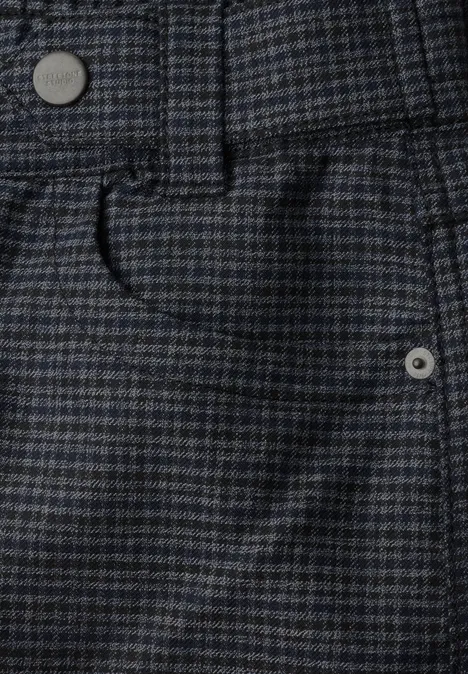 Gros plan sur un tissu de pantalon à carreaux bleu-gris, ceinture, passant et poche avant.