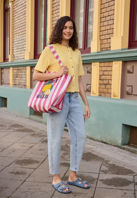 Canvas Shopper mit Streifenmuster multicolor Eine Frau in gelbem Oberteil und Jeans steht vor einem Gebäude und trägt eine rosa-weiß gestreifte Tasche.