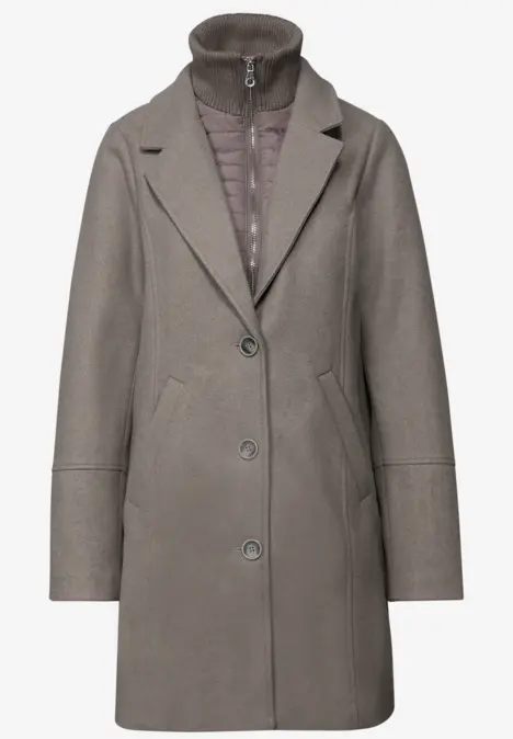 Grauer Damenmantel mit Reverskragen und integrierter Steppjacke, knieumspielende Länge.