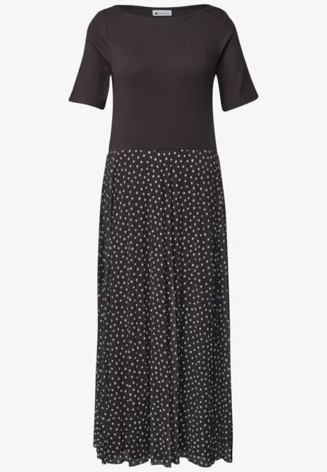 Schwarzes Kleid mit halblangen Ärmeln und gepunktetem, fließendem Rock.