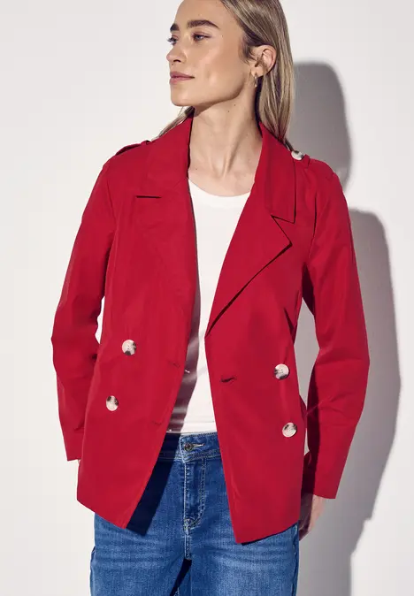 Frau trägt roten Blazer, weißes Shirt und Jeans.