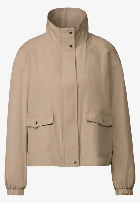 Beige Damenjacke mit Stehkragen und Taschen.