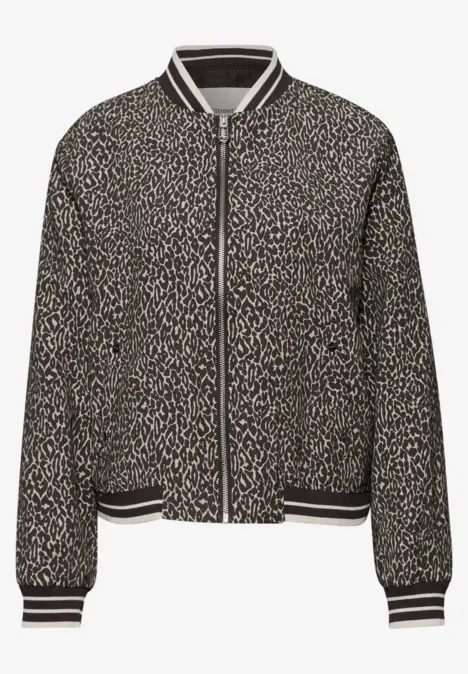 Schwarze Bomberjacke mit weißem Leoparden-Muster und kontrastierenden Streifen an Bündchen.