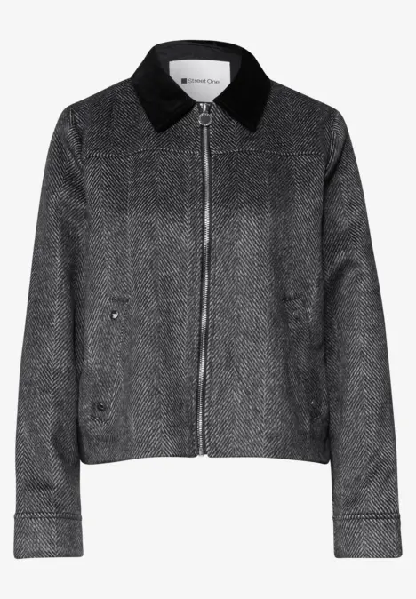 Veste grise zippée, col noir et poches latérales.