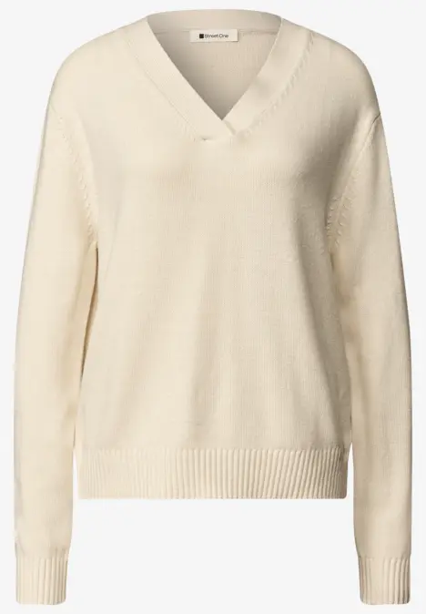 Beiger Strickpullover mit V-Ausschnitt, langen Ärmeln und Rippbündchen an Saum und Ärmeln.