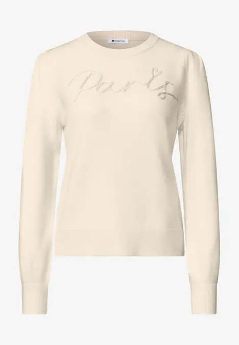 Cremefarbener Pullover mit Rundhalsausschnitt, langen Ärmeln und dezenter Schriftstickerei auf der Brust