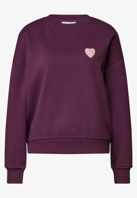 Dunkellila Damenpullover mit langen Ärmeln, geripptem Saum und kleinem rosa Herz-Logo auf der Brust.