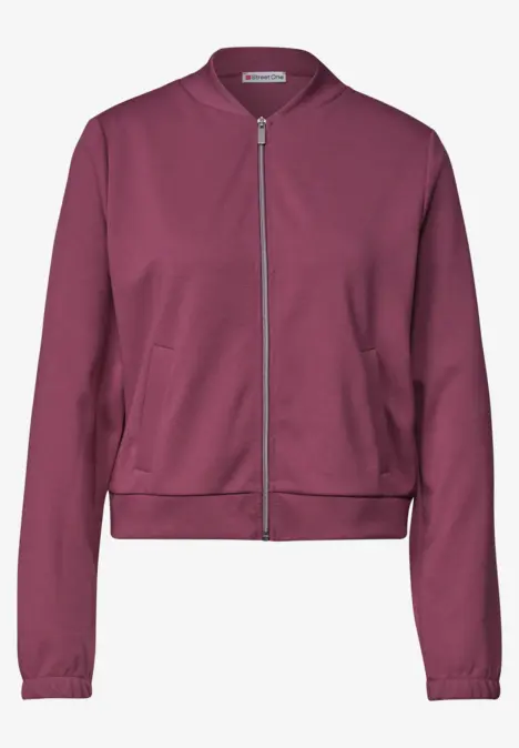 Blouson bomber femme bordeaux à fermeture éclair et deux poches latérales.