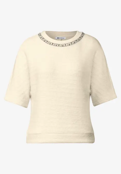 Pull court beige-crème à manches courtes, texture subtile et col rond.