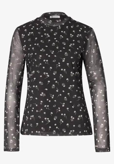 Schwarzes, langärmeliges, leicht transparentes Shirt mit zarten weißen Blumenmustern.