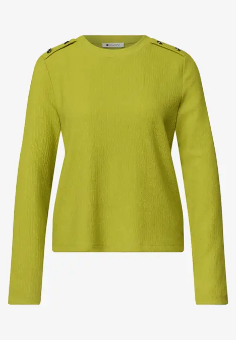 Langärmliger, hellgrüner Pullover mit Knopfdetails an den Schultern.