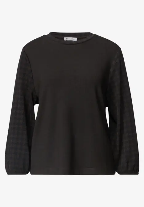 Schwarzes Langarmshirt mit leicht ballonförmigen Ärmeln und dezent geometrischem Muster